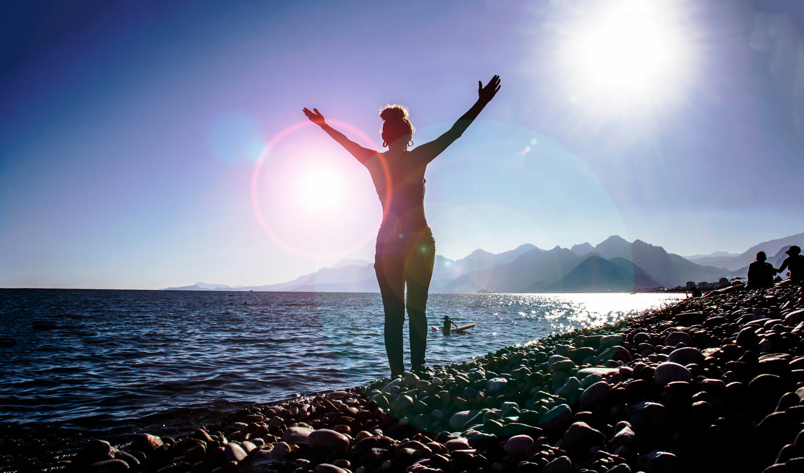 Woman standing on rocky shores of a lake